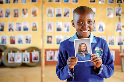 Portrait of Mary Nzioki holding a picture of her sponsor.
